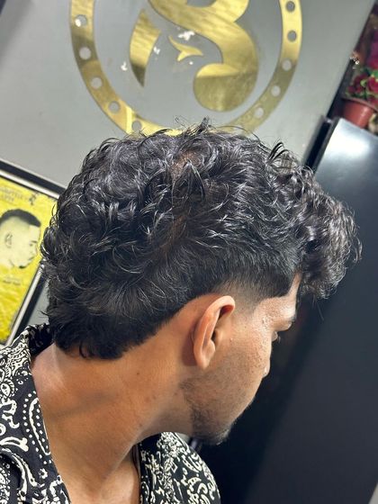 The back view of a curly hair mullet, showing the texture and length I left to create the signature style.