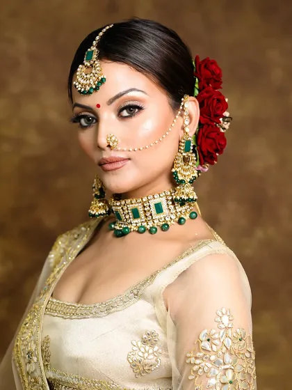 A classic bridal look featuring a flawless base, neutral shimmery eyes, and a beautiful floral hair bun. This style is perfect for the bride who wants a timeless and elegant wedding day appearance.