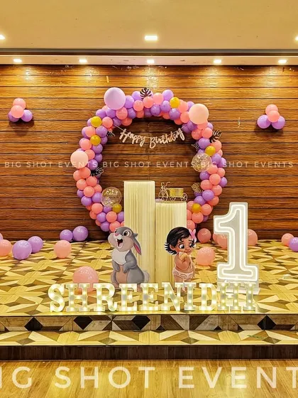 A first birthday celebration at JCP Restaurant, where we used the wooden wall as a natural backdrop for a circular balloon arch, marquee number '1', and a light-up name sign.