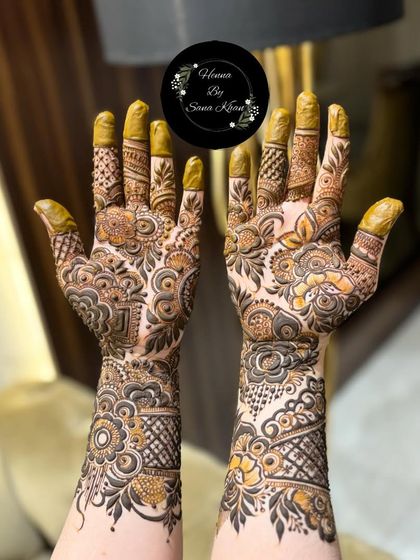 A rich and dense floral design covering the hands and wrists, perfect for a bride who wants a full and traditional look.