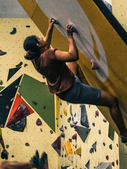 This action shot from a workshop shows a climber fully engaged with a route. Our goal is to get you moving, problem-solving, and experiencing the joy of climbing.