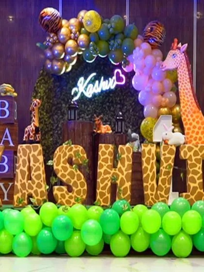 A vibrant jungle-themed birthday party stage setup, complete with large animal cutouts and extensive balloon decorations. This showcases our ability to photograph any party theme you can imagine.