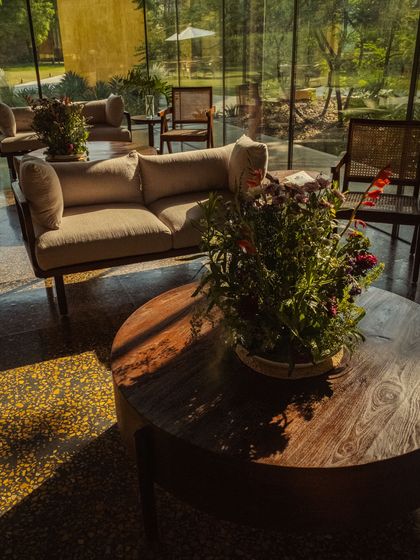 The lounge area, with its terrazzo floors and glass walls, is filled with natural light and thoughtful floral arrangements.