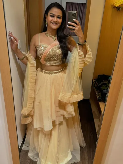 A mirror selfie showing off the details of my peach sangeet lehenga. This provides a personal, behind-the-scenes feel that is great for social media.