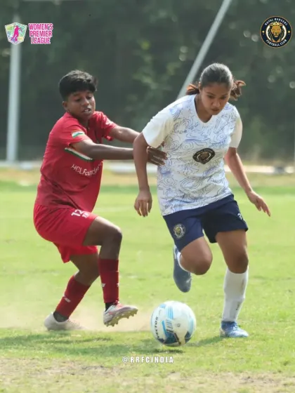 Driving forward with the ball. Our player pushes past a defender, showing determination and skill to advance the play up the field.