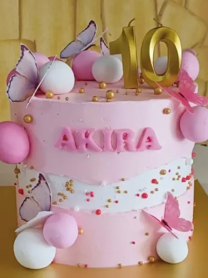 A dreamy butterfly cake for a 10th birthday. The soft pink frosting, delicate edible butterflies, and touches of gold create a whimsical and elegant design perfect for a special milestone.