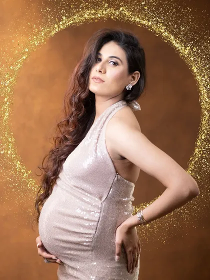 For the mom who wants to feel like a star. This high-fashion solo portrait in a glittering sequin gown, complete with professional hairstyling and makeup, highlights the glamorous and empowering side of our maternity sessions.
