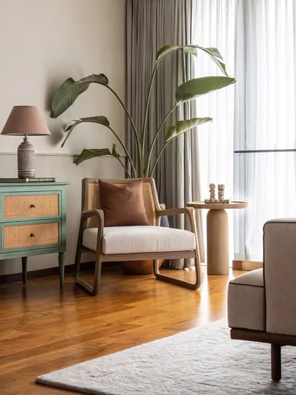 A comfortable reading nook designed for pause and reflection. The mix of a modern armchair, a rustic side table, and a pop of color from the cabinet creates an inviting corner.