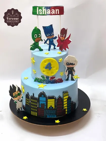 A two-tier PJ Masks theme cake for a 4th birthday. This vanilla truffle cake features the heroic trio Catboy, Owlette, and Gekko, ready for a night of adventure.