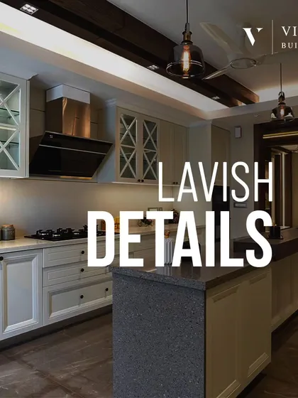 Lavish details define this kitchen. The design features classic shaker style cabinets with 'X' mullions, an island with a breakfast bar, and elegant pendant lighting.