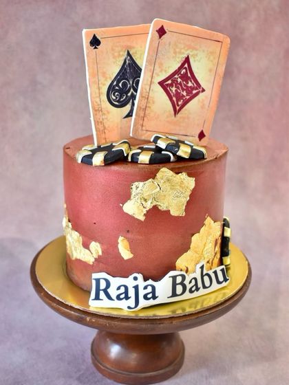 All in for this casino-themed cake. Perfect for a poker night or a milestone birthday, this cake features edible playing cards, poker chips, and gold leaf accents.