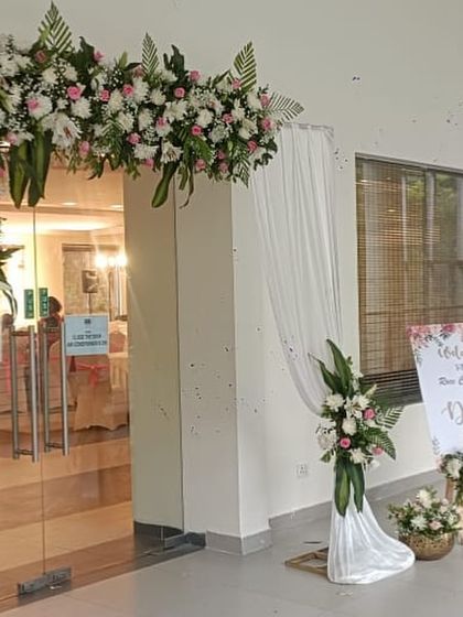 The entrance decor for the Roce Ceremony, featuring a floral arch and welcome sign that coordinates with the main stage.
