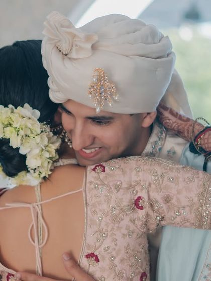A heartfelt hug. Her gajra-adorned bun and flawless makeup stay perfect, allowing her to fully embrace the emotions of the day.