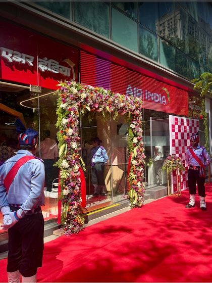 The grand entrance for an Air India event in Mumbai, featuring a red carpet and floral arch. We provide comprehensive catering services for major corporate launches and celebrations.