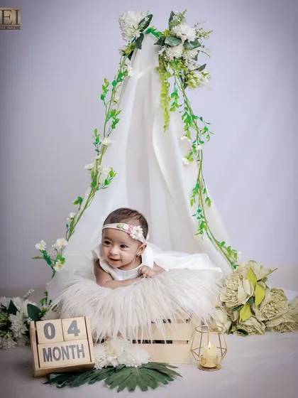 Another angle from our four-month milestone shoot, showing the full setup with the floral teepee and soft fur rug, creating a dreamy and gentle scene.