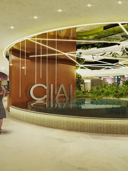 This render for the Cochin Airport shows a central water feature surrounded by retail spaces. The design uses water and light to create a dynamic focal point, enhancing the ambiance of the commercial area and improving the passenger experience.