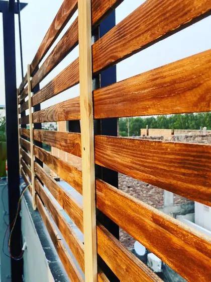 A close-up of the pinewood privacy screen during installation, showing the quality of the wood and the craftsmanship.