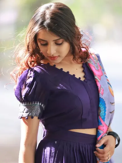 A close-up portrait focusing on the model's pensive expression and the details of the puff-sleeve blouse.