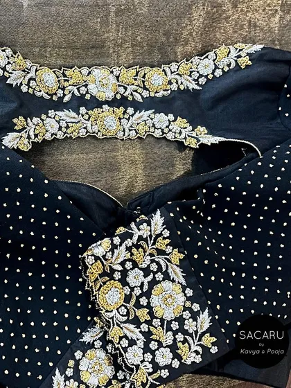 A detailed close-up of the gold and silver floral embroidery on the black georgette sleeves, contrasted with delicate polka dots.