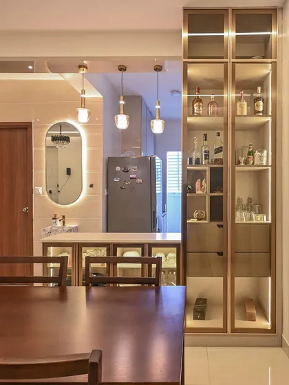For the Aarohi Residence, we designed a seamless dining and kitchen area that balances elegance and function. A custom, back-lit bar and crockery unit provides sophisticated storage, while pendant lighting adds a warm ambiance to the space.