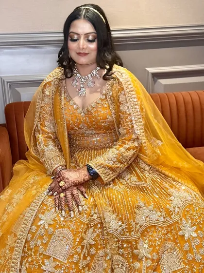 A stunning engagement look in a vibrant yellow lehenga. The makeup features a bronze smokey eye to complement the warm tones.