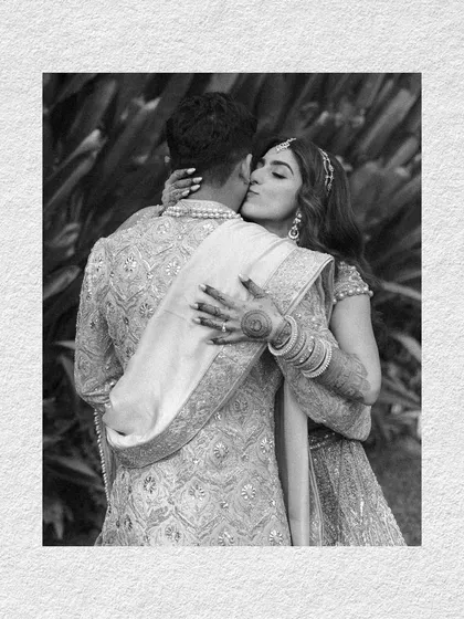 A tender kiss on the cheek, a moment of quiet affection captured in black and white against the lush green backdrop of a Goa resort.
