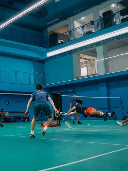 This is what dedication looks like. A player diving with full commitment during an intense badminton training session, capturing the high-energy atmosphere of our courts.