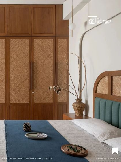 The master bedroom in Oatmeal House is a blend of clean aesthetics and warm textures. We designed a custom wardrobe with woven cane panels and a bed with a teal upholstered headboard, creating a tactile and visually soothing environment for rest and relaxation.