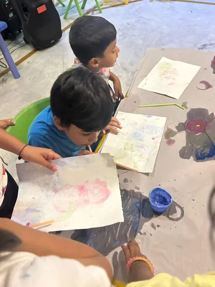 Two young children deeply focused on a bubble painting activity. This sensory art technique is always a huge hit, creating beautiful patterns with minimal mess.