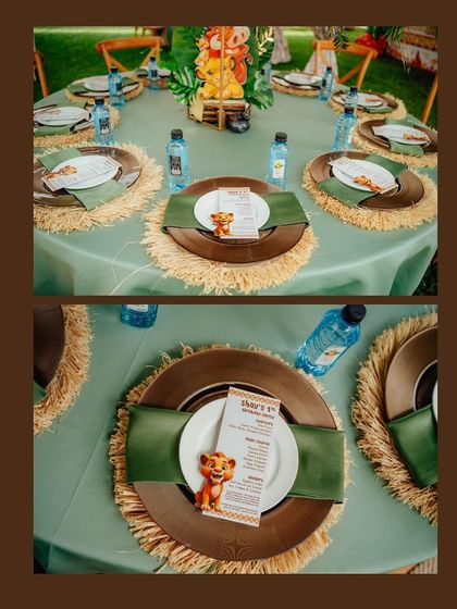 Themed place settings are key to a cohesive look. Here, you can see custom menus with a Simba graphic, placed on wooden chargers with natural fiber placemats and green napkins.