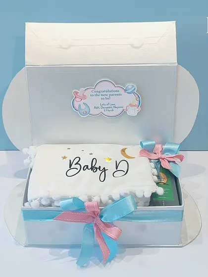 Celebrate the journey to parenthood with this 'Touch of Heaven' hamper. The cloud-shaped box opens to reveal a personalized pillow and other essentials for the parents-to-be.