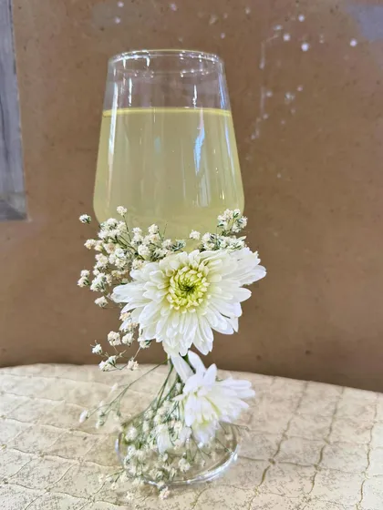 An elegantly presented mocktail, adorned with fresh white chrysanthemums. We believe that even the simplest drink can be turned into a work of art.