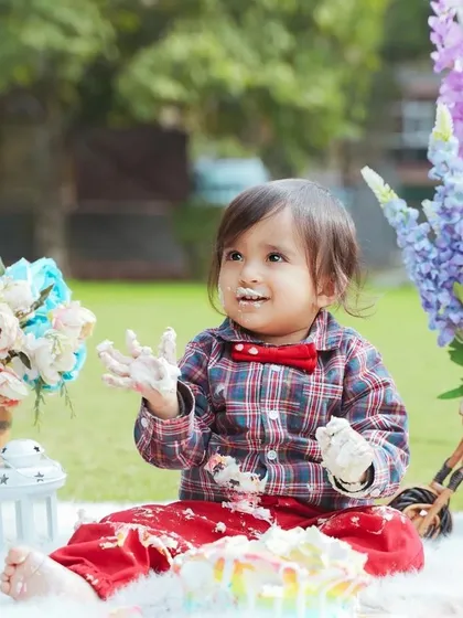 An outdoor cake smash session is a great option for a natural and fun setting. This little boy is having a wonderful time celebrating his first birthday in the park.