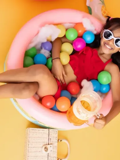 Chilling in the ball pit pool, this little fashionista is serving major summer vibes during our fun, colorful pool party themed shoot.