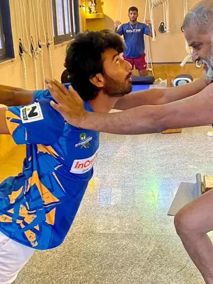 A partner adjustment to open the chest and shoulders in a standing pose. This helps the athlete feel the correct rotation in the upper arms and the lift of the chest.