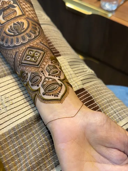 A close-up of the lower part of the arm band, demonstrating how to connect the main design to the wrist.