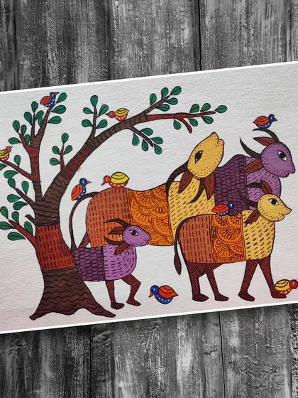 A family of goats stands by a tree in this charming Gond art painting by Ayako Sagara. The bodies of the animals are filled with different traditional patterns, and the scene is full of life with small birds all around.