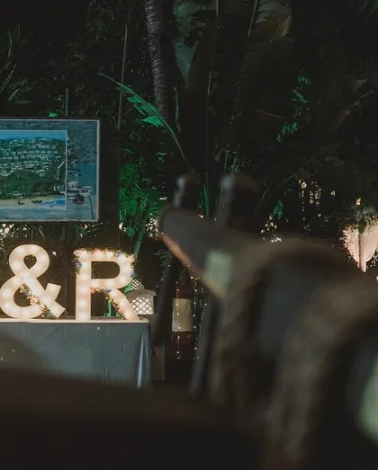 The couple's initials, lit up at night, become a beacon for the celebration. This shows how personalized elements can also serve as landmarks within a large venue.