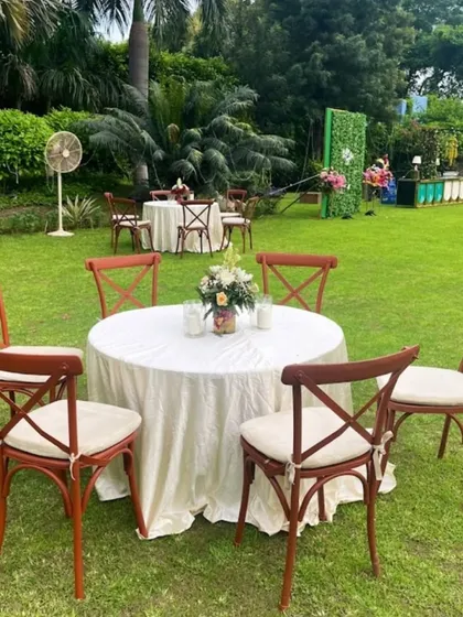 A simple and elegant outdoor seating arrangement on a lawn, perfect for a small gathering or a relaxed lunch event.