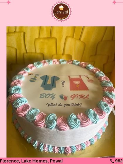 A sweet and simple gender reveal cake. The top features an edible print with the classic "Boy or Girl?" question, framed by pink and blue buttercream swirls. The real secret is hidden inside with colored cake layers.