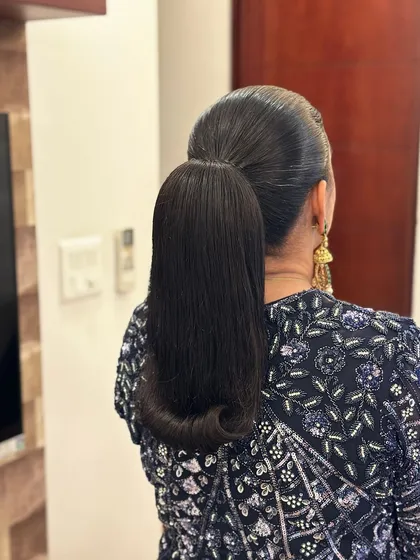 A super sleek ponytail with a perfectly wrapped hair cuff at the base. This is a timeless and powerful look, ideal for corporate events or minimalist fashion campaigns.