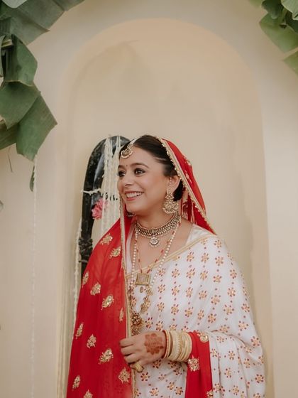 A series of portraits of a bride in a beautiful, traditional white and red saree, capturing her elegance, emotion, and moments with her family.