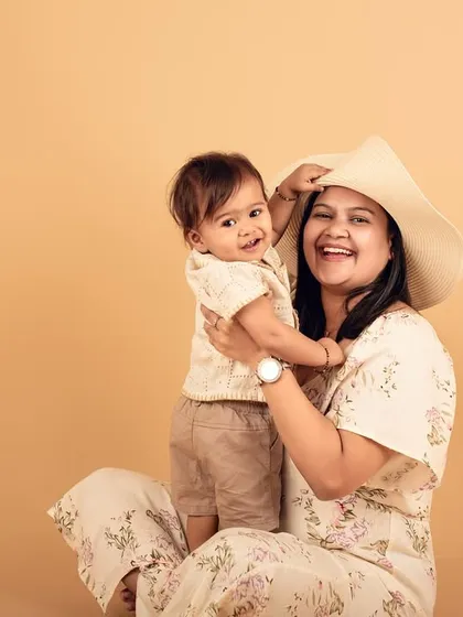 A playful moment between mother and child in the studio. Using simple props like a hat can add a fun element to your family portraits.