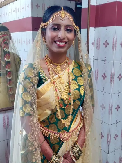 A classic South Indian muhurtham look for a beautiful bride. The cream and green Kanjivaram saree is draped traditionally, ensuring the pleats fall perfectly and the bride is comfortable throughout the long ceremony.