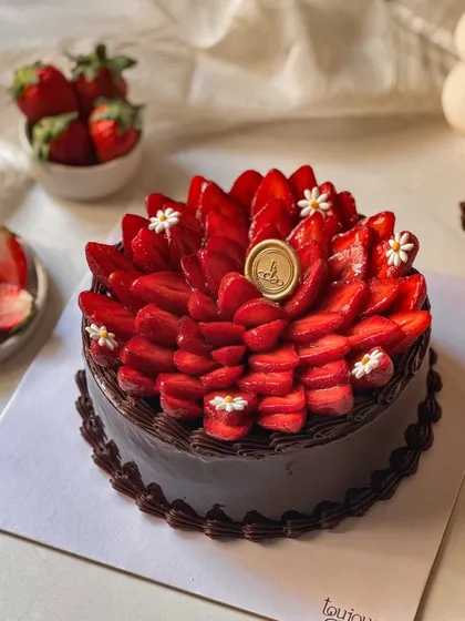 Our Chocolate Strawberry Cake, a classic pairing elevated to new heights. A rich chocolate cake is generously topped with a beautiful fan of fresh, juicy strawberries, making it a seasonal best-seller.