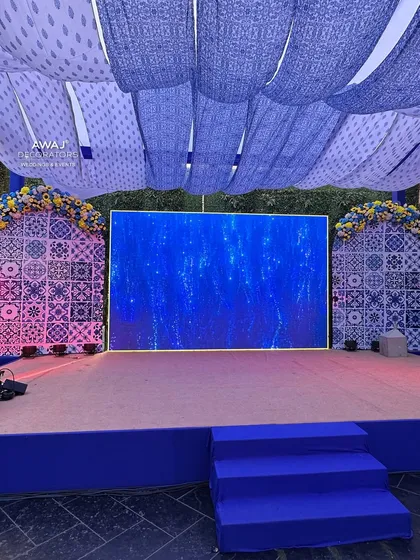 The main stage for the Haldi event, featuring a large LED screen set within a backdrop of traditional blue and white patterns.