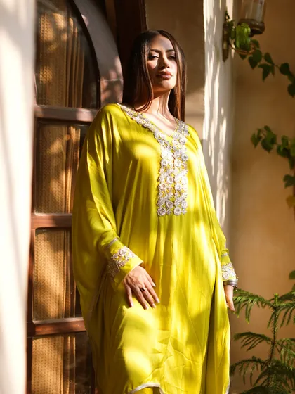 A dreamy shot in a lime green embroidered kaftan, perfect for a relaxed yet glamorous festive look.