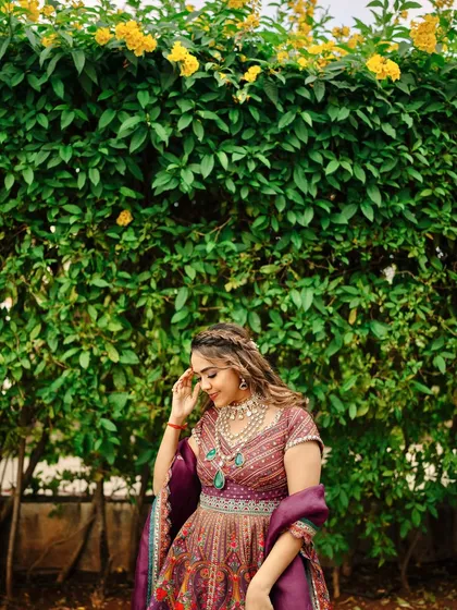 A lovely candid moment. Her makeup looks fresh and natural, perfect for an outdoor Mehendi celebration.