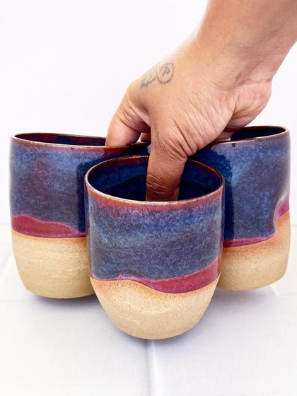 Holding a set of three Celestial Dunes grip mugs. The glaze combination reminds me of a desert landscape under a starry sky.