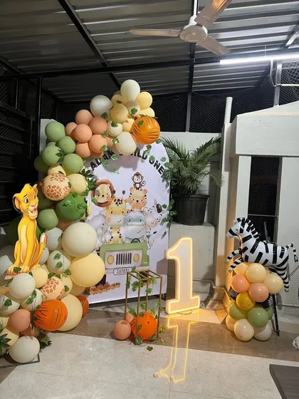 A 'Wild One' jungle safari is one of my most requested themes for first birthdays. For little Adam's party, I built a lush balloon garland with greens, oranges, and animal prints, complemented by a Simba cutout, a themed backdrop, and a bright, light-up number '1' to mark the special day.